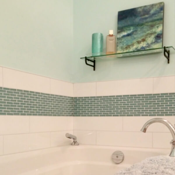clean white tub with blue glass accent tiles