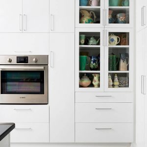 galley kitchen with Teal tile, white cabinets, stainless steel appliences, and dark quartz counters Halifax Case Design