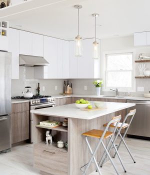 A modern wood grain style kitchen redesign featuring an island with pull up chairs and plenty of nooks for storage